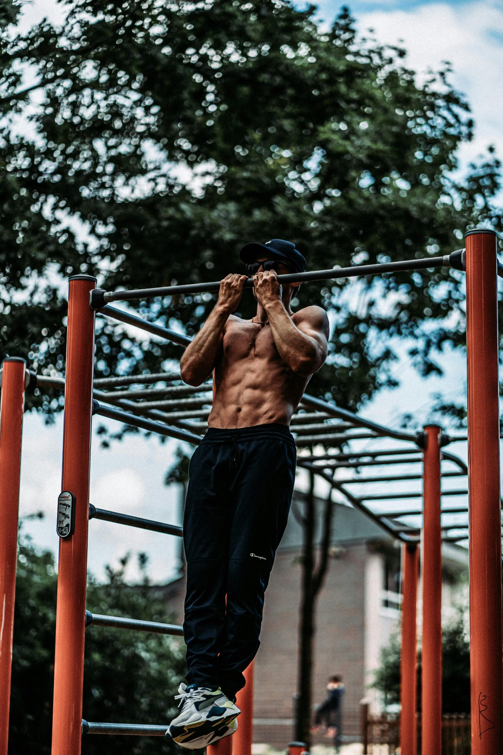 Hombre haciendo una dominada en un parque de calistenia